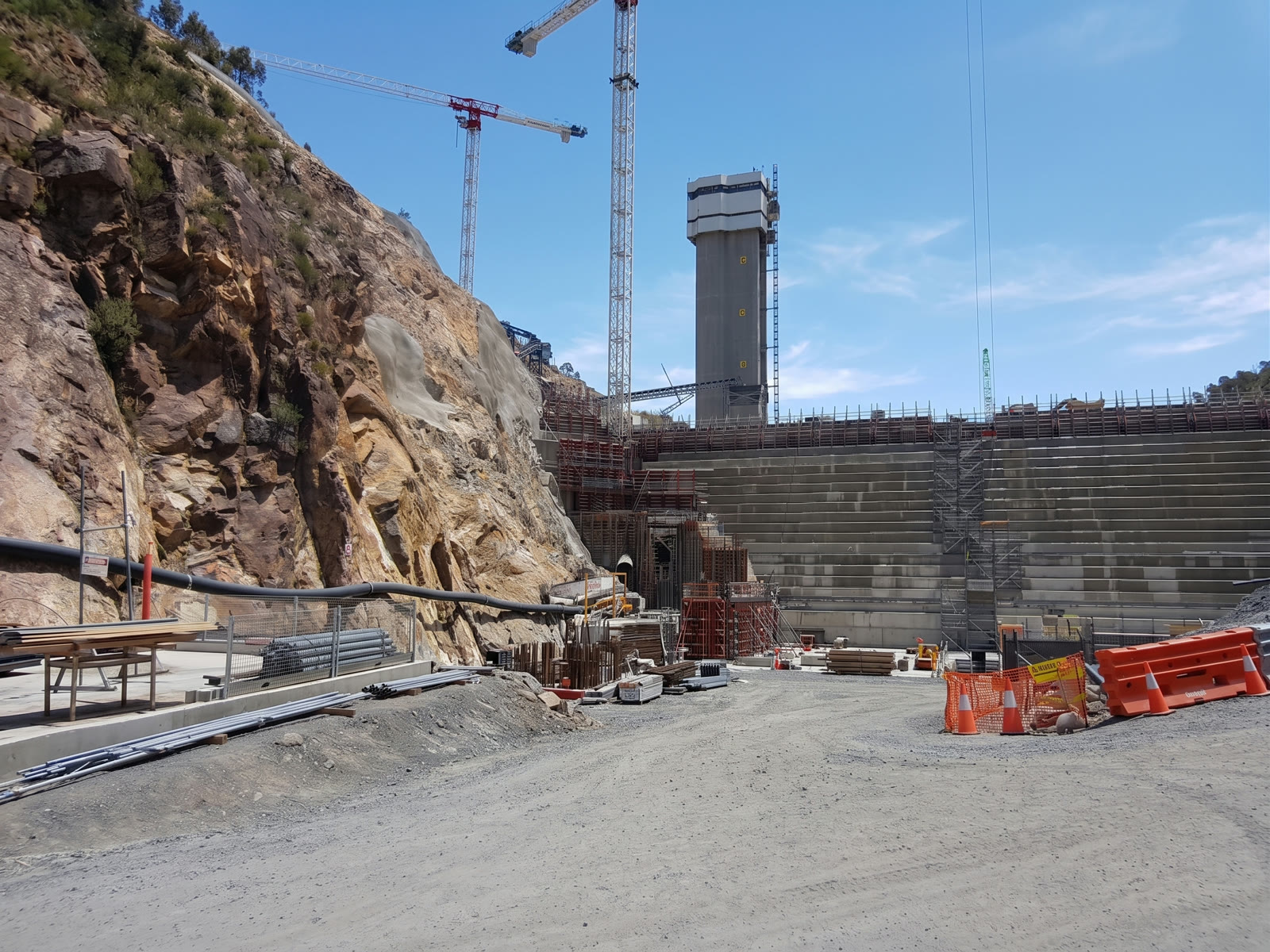 Two tower cranes over a dam wall under construction
