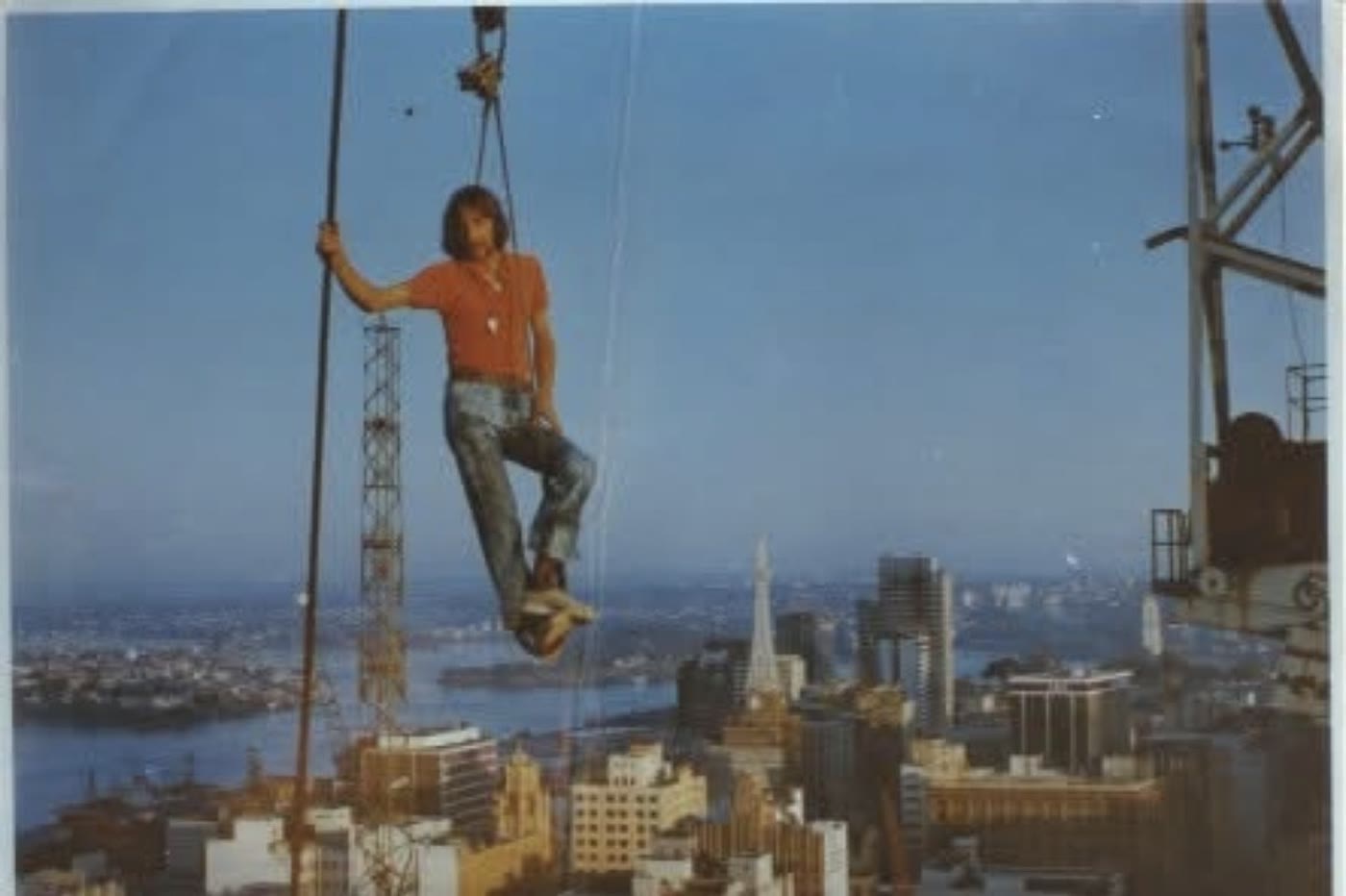 A rigger riding the crane hook high above Sydney in 1972
